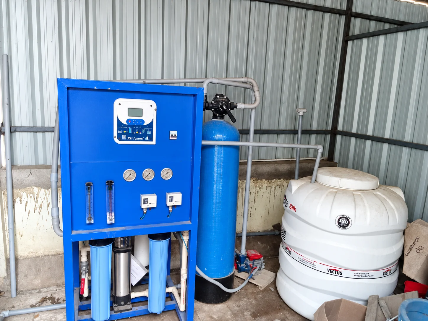 Reverse osmosis installation with a blue control panel, filter vessel and water storage tank