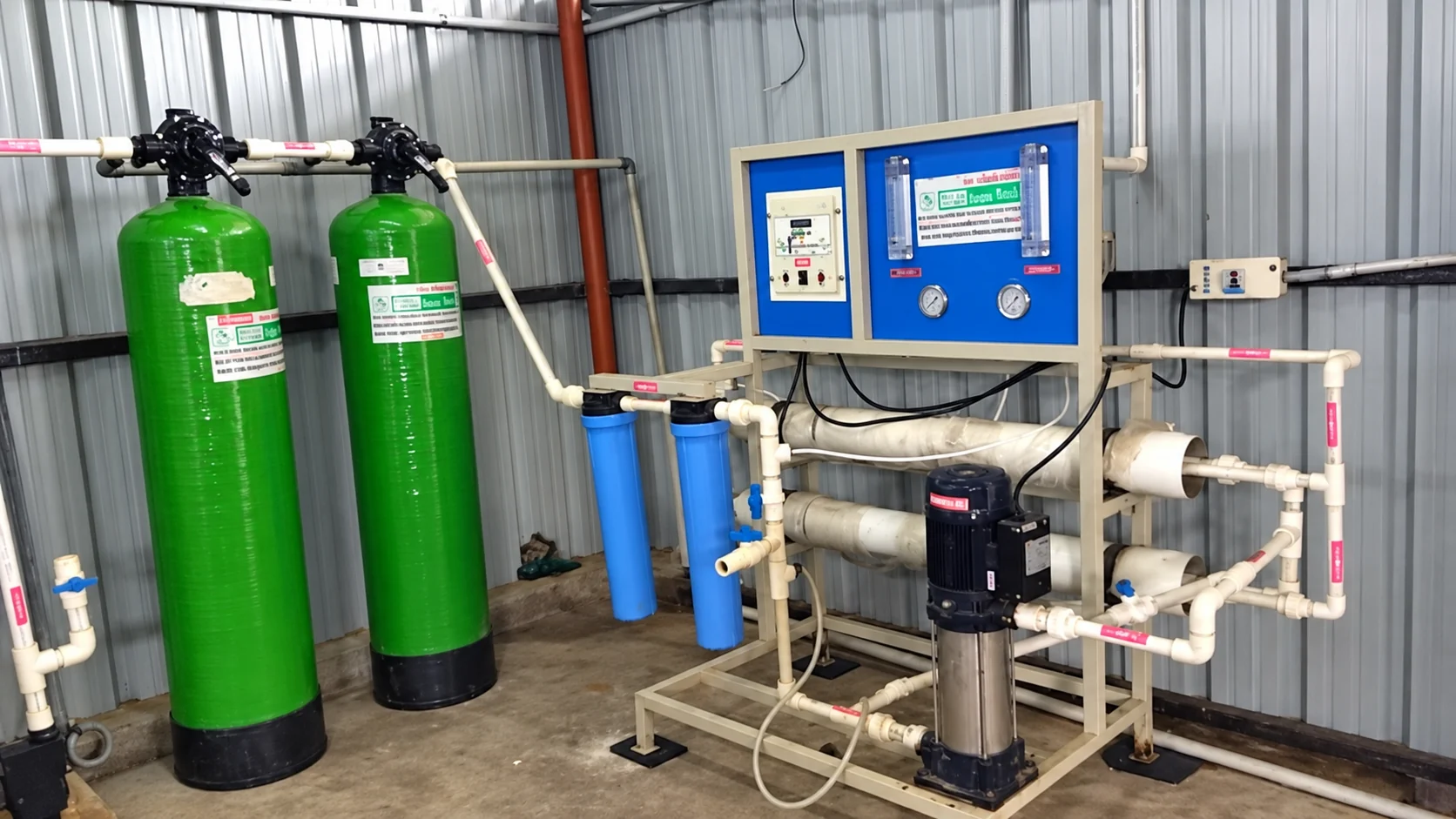 Water treatment installation with twin green filter vessels, blue control panel and reverse osmosis membranes